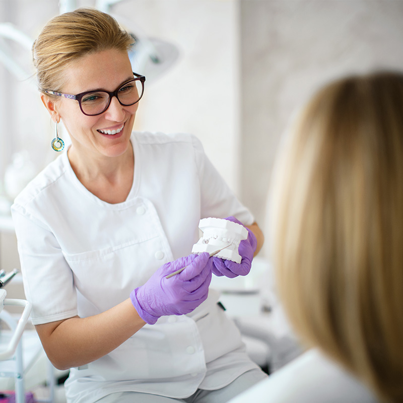 Dentist showing dental plaster mold to the patient