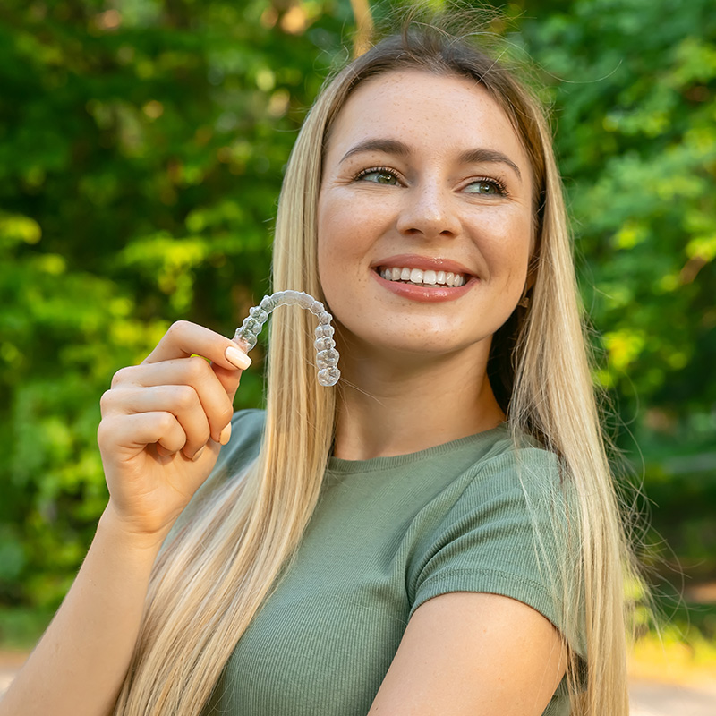 Woman with perfect smile after invisible dental aligners aligners treatment.